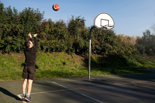 Przyjaciele w średnim wieku bawią się razem grając w koszykówkę