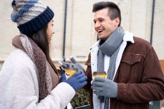 Przyjaciele z filiżankami kawy ponownie spotkali się po długim czasie spędzonym na świeżym powietrzu