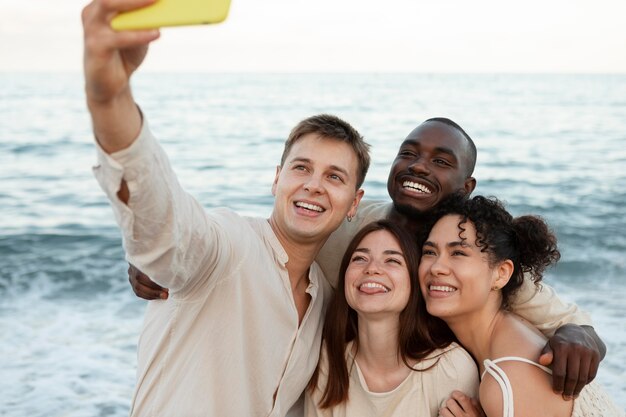 Przyjaciele ze średnim strzałem robiący selfie na zewnątrz