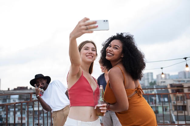 Bezpłatne zdjęcie przyjaciele ze średnim ujęciem robiący selfie