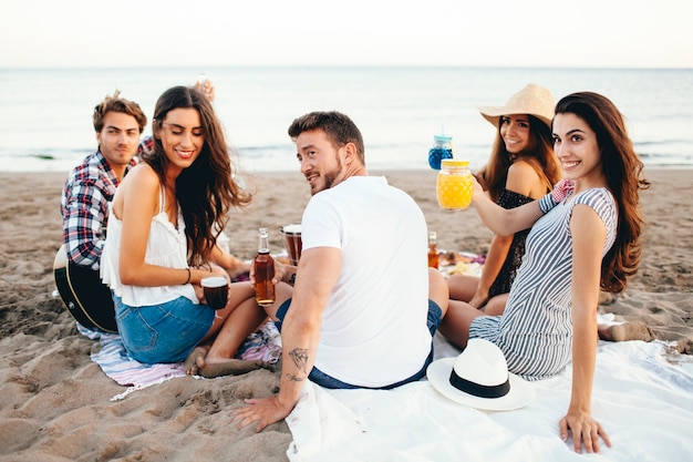 Bezpłatne zdjęcie przyjaciół siedzi na plaży