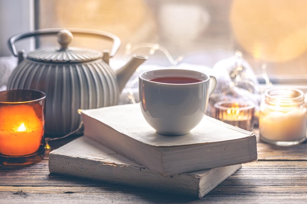 Bezpłatne zdjęcie przyjemna kompozycja z książkami i filiżanką herbaty przy oknie