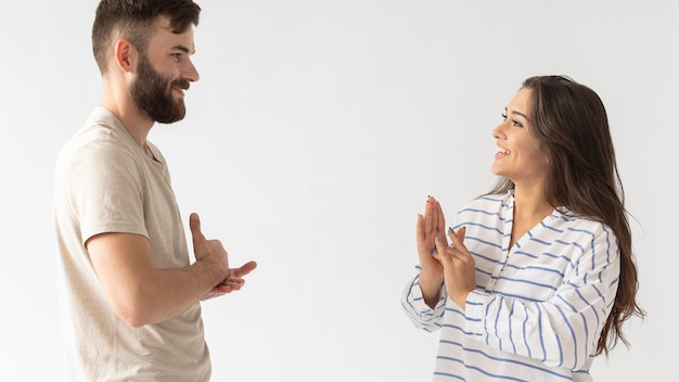 Bezpłatne zdjęcie przypadkowy mężczyzna i kobieta komunikują się za pomocą języka migowego