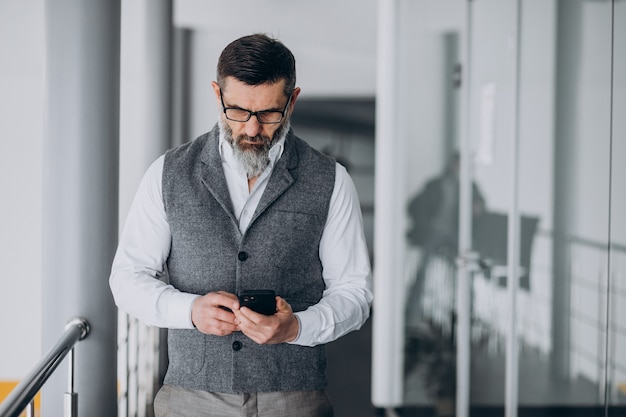 Przystojny biznesmen rozmawia przez telefon w biurze