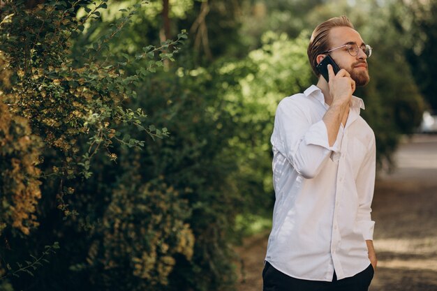 Przystojny brodaty mężczyzna rozmawia przez telefon