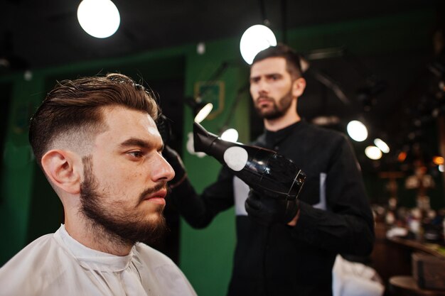 Przystojny brodaty mężczyzna u fryzjera fryzjera w pracy
