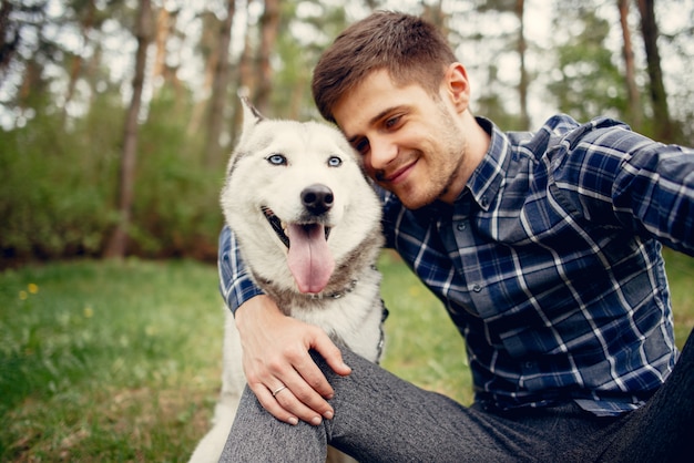 Bezpłatne zdjęcie przystojny facet w lato parku z psem