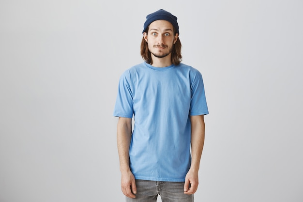 Przystojny hipster facet w niebieskiej koszulce i czapce