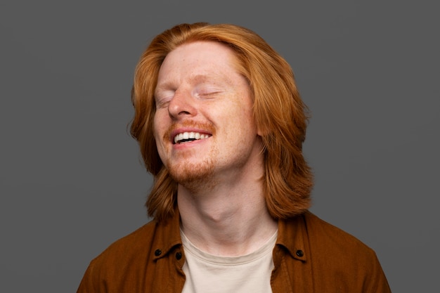 Bezpłatne zdjęcie przystojny i wrażliwy rudy mężczyzna uśmiechający się