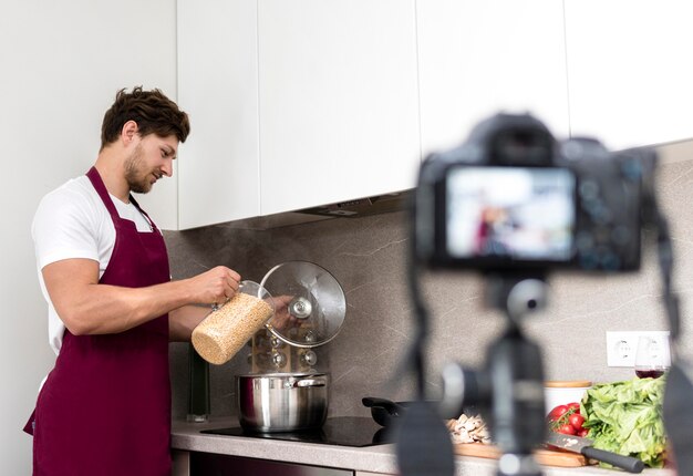 Bezpłatne zdjęcie przystojny męski nagrywanie kulinarny wideo w domu