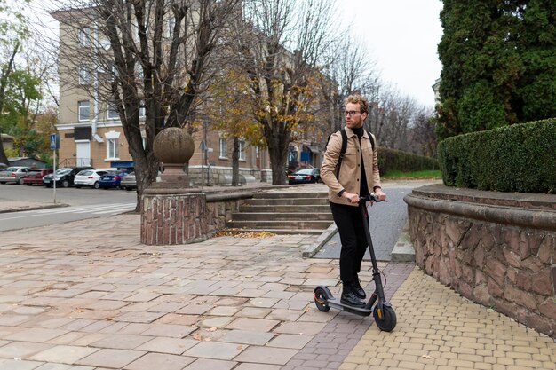 Przystojny mężczyzna jedzie na skuterze elektrycznym