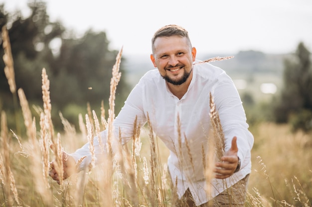 Przystojny mężczyzna na zewnątrz w złotym polu