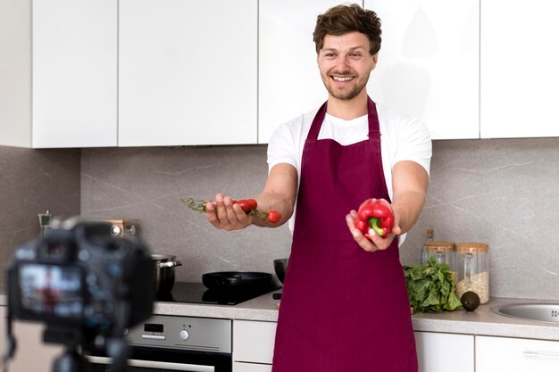 Bezpłatne zdjęcie przystojny mężczyzna nagrywa kulinarnego wideo w domu