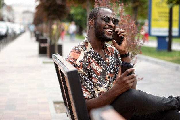 Bezpłatne zdjęcie przystojny mężczyzna rozmawia przez telefon na zewnątrz