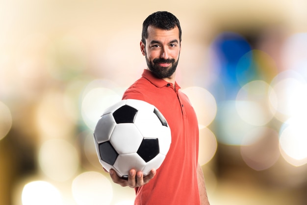 Przystojny mężczyzna trzyma piłkę nożną