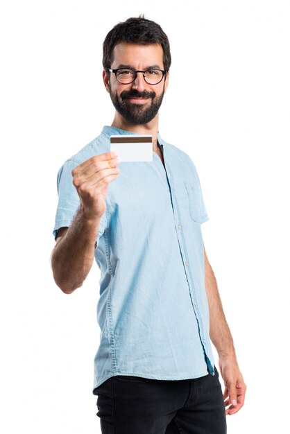 Przystojny mężczyzna z niebieskimi okularami posiadania karty kredytowej