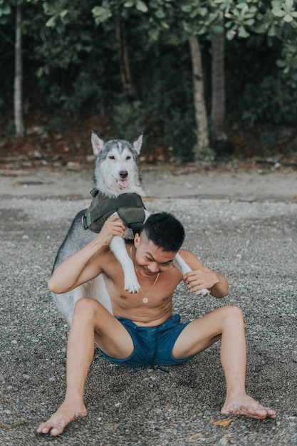 Przystojny nastolatek z Filipin bawi się ze swoim syberyjskim husky zwierzakiem