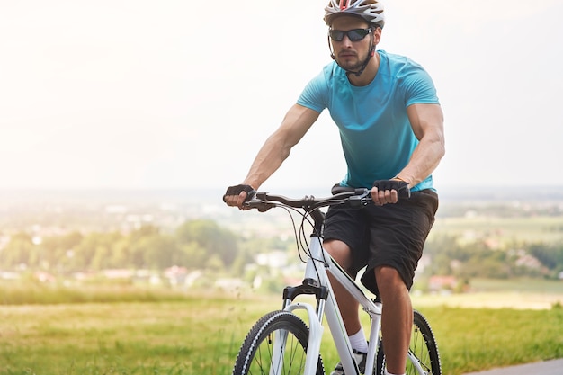 Przystojny rowerzysta na letniej jeździe na rowerze