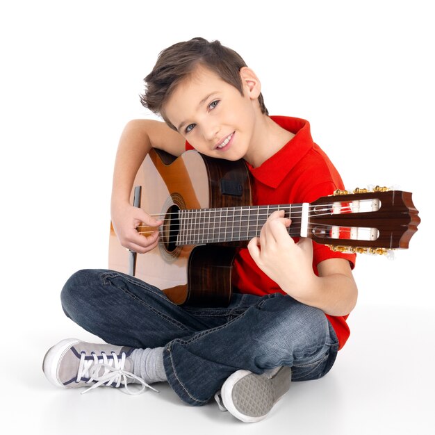Przystojny szczęśliwy chłopiec gra na gitarze akustycznej