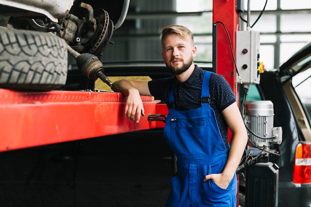 Przystojny technik przy samochodowym warsztatem