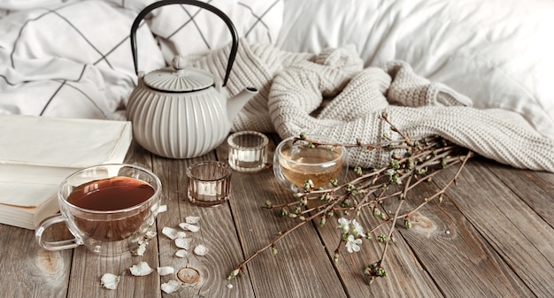 Bezpłatne zdjęcie przytulna wiosenna martwa natura ze świecami, herbatą, czajnikiem na drewnianej powierzchni w stylu rustykalnym.