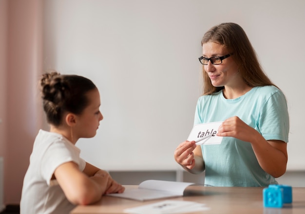 Psycholog pomaga małej dziewczynce w logopedii