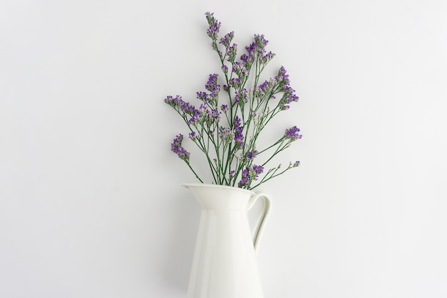 Bezpłatne zdjęcie purpurowe kwiaty na białym wazonie