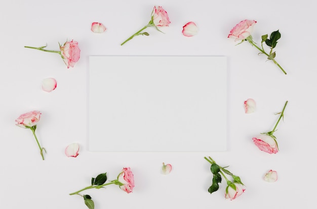 Bezpłatne zdjęcie pusta karta otoczona delikatnymi różami