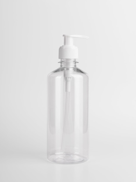 Pusta plastikowa przezroczysta butelka z dozownikiem airless pompka z etykietą i reklamami żelu, mydła, alkoholu, kremów i kosmetyków.