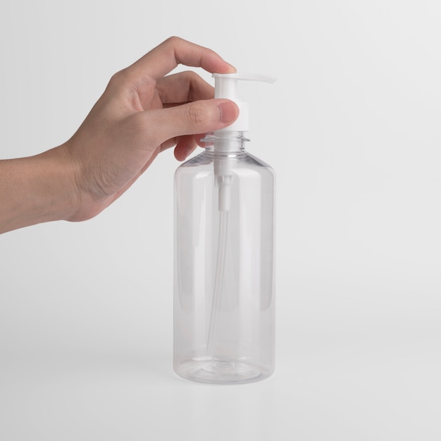 Pusta plastikowa przezroczysta butelka z dozownikiem airless pompka z etykietą i reklamami żelu, mydła, alkoholu, kremów i kosmetyków.
