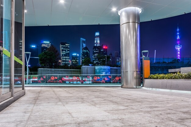 Pusta podłoga z nowoczesną panoramę i budynki w nocy w Szanghaju