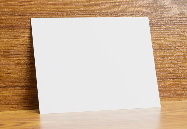 Pusta rama papieru a6 zablokowana na drewnianym biurku z teksturą