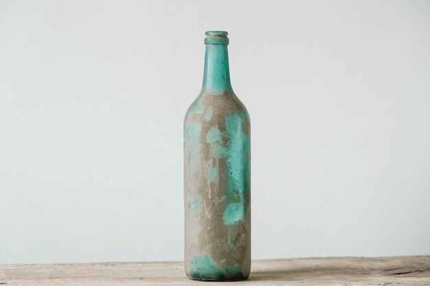 Pusta szklana butelka w błocie na drewnianym stole. kopiuj, puste miejsce na tekst