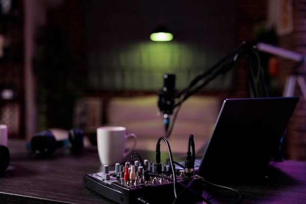 Puste biurko ze sprzętem do podcastów do nagrywania talk show na żywo w domu. Żadne osoby w salonie nie są wykorzystywane do vlogowania online i nadawania rozmów z mikrofonem, produkcji dźwięku.