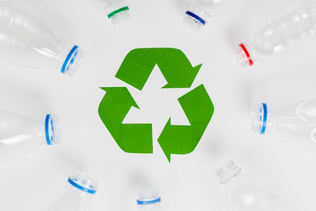 Bezpłatne zdjęcie puste butelki z tworzyw sztucznych wokół ikony recyklingu