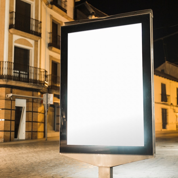 Puste miejsce iluminujący pionowo billboard przy nocą