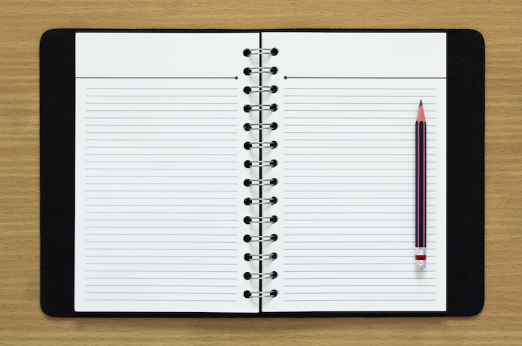 Bezpłatny plik Zdjęcie puste spirali notebooka io? ówek na tle drewna