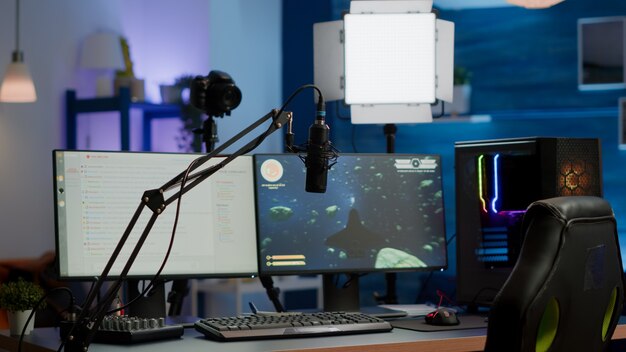 Puste studio gier z oświetleniem LED RGB, potężny komputer osobisty do strumieniowej rywalizacji online. Wyświetlacz z czatem strumieniowym przygotowanym do wirtualnego turnieju, salon, w którym nikt nie wchodzi