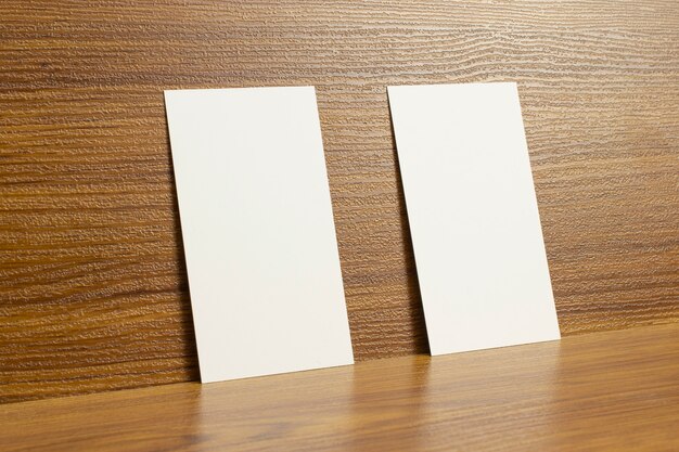 Puste wizytówki zamknięte na drewnianym teksturowanym biurku o wymiarach 3,5 x 2 cale