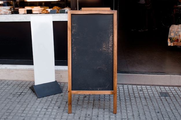 Pusty blackboard menu i biały billboard przed restauracją przy ulicą