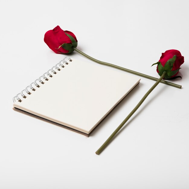 Pusty notepad z różami na stole