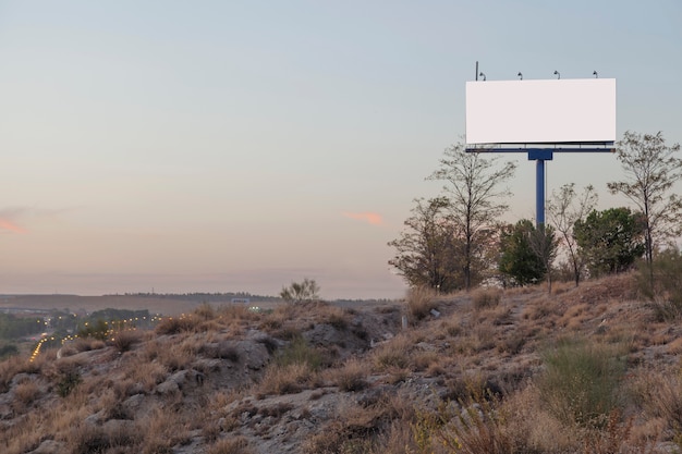 Bezpłatne zdjęcie pusty reklamowy billboard na górze przeciw niebu