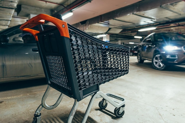 Pusty wózek na parkingu podziemnym. koncepcja zakupów. kopiuj przestrzeń