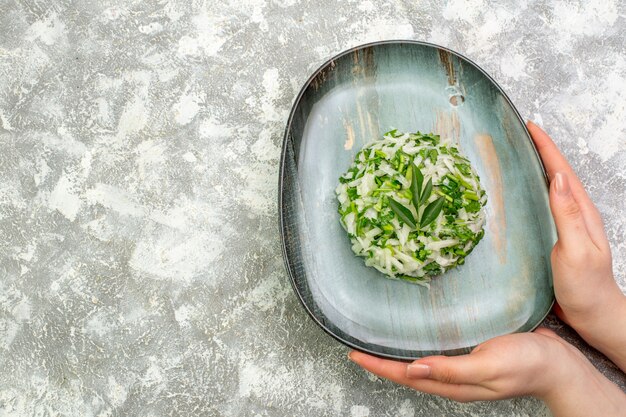 Pyszna sałatka z widokiem z góry składa się z zieleni i kapusty wewnątrz talerza