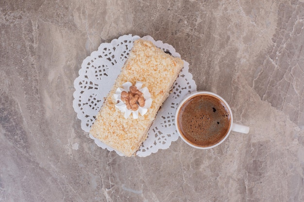 Pyszne ciasto i filiżanka kawy na marmurowej powierzchni.