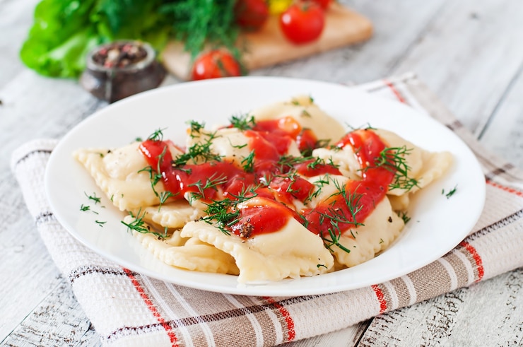 Bezpłatny plik Zdjęcie pyszne ravioli z sosem pomidorowym i koperkiem