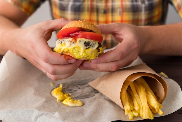 Bezpłatne zdjęcie pyszne ręce cheeseburger gospodarstwa