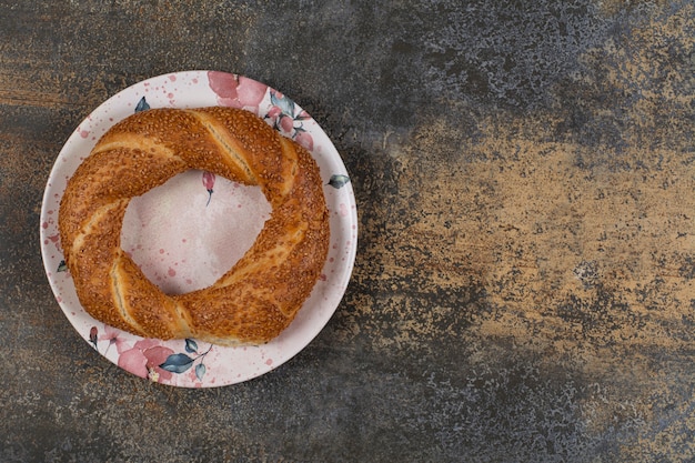 Pyszny simit z sezamem na kolorowym talerzu