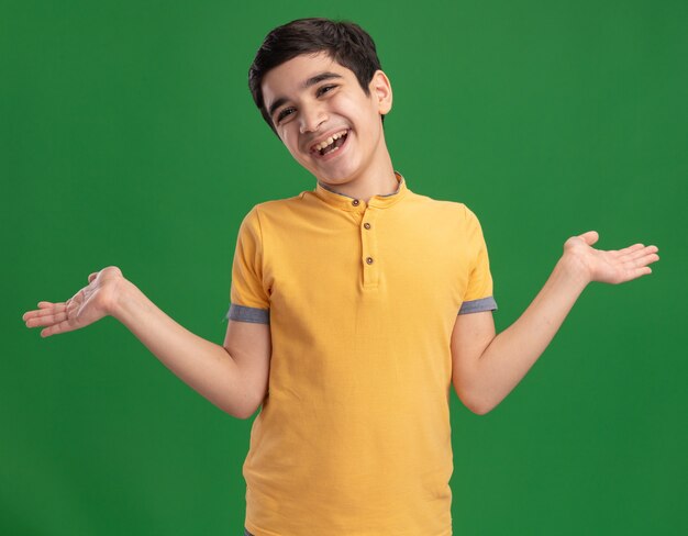 Radosny młody chłopiec kaukaski pokazując puste ręce patrząc na bok