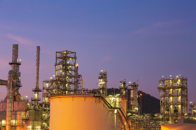 Rafineria ropy naftowej i fabryka przemysłu petrochemicznego zbiorniki na ropę i gazy przemysł z chmurą niebo na tle zachodu słońca.